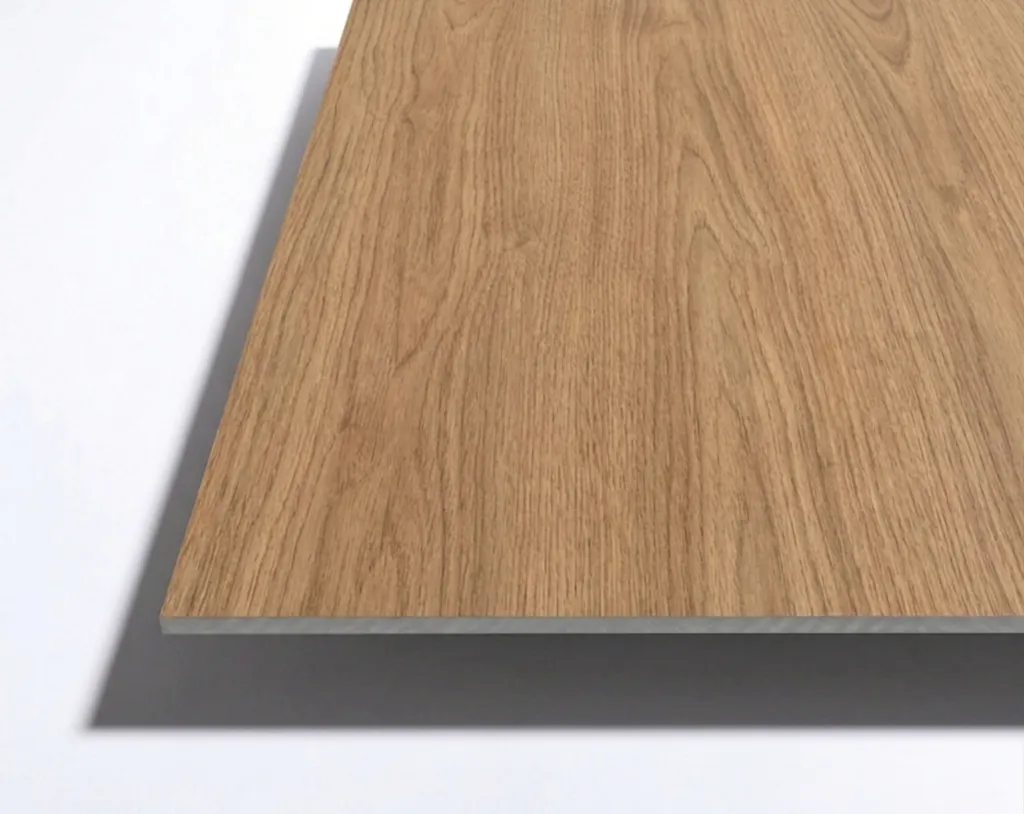 A close-up view of the corner of a rectangular wooden board with a light brown wood grain pattern, placed on a white surface.